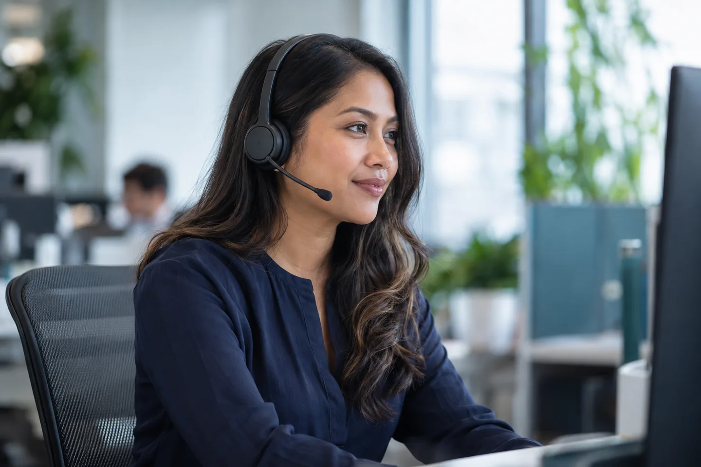 Customer service professional wearing a headset at her workstation; illustrative photo.